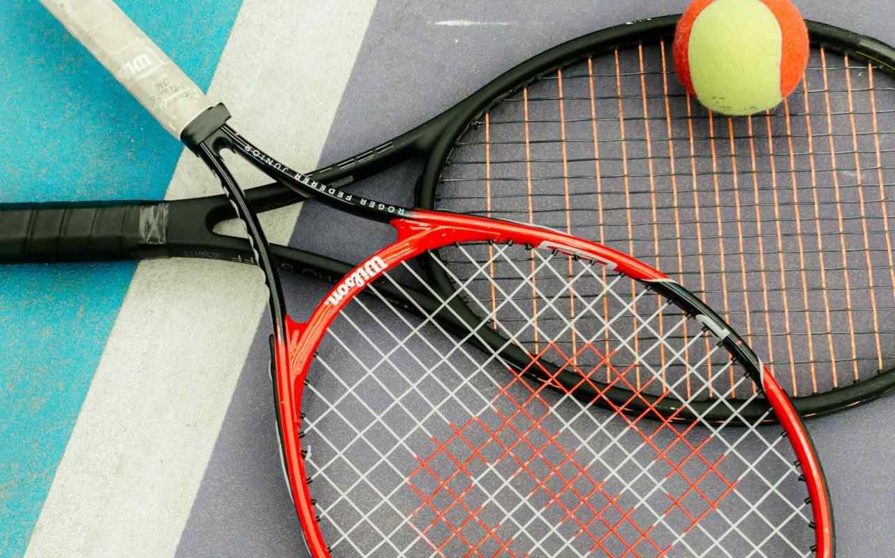 Dva reketa za tenis i loptice na terenu